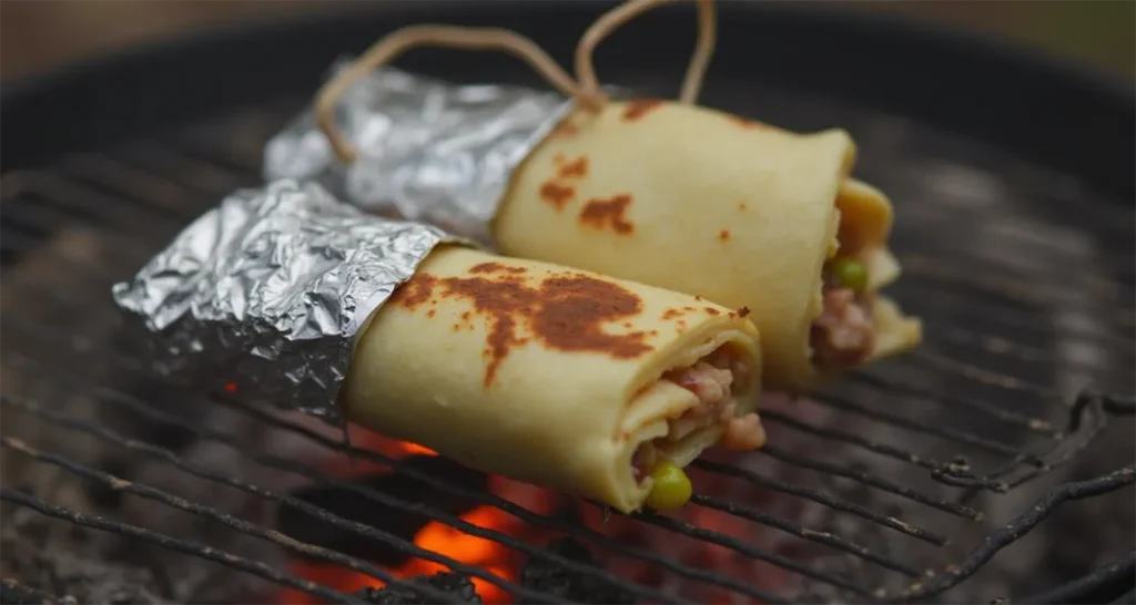 Car Camping Meals: Foil-wrapped breakfast burrito cooking over a campfire.