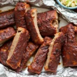 Perfectly sliced BBQ ribs served with baked beans, coleslaw, and cornbread.