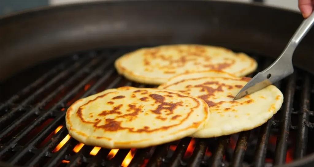 Tortillas warming in a Dutch oven over a fire.